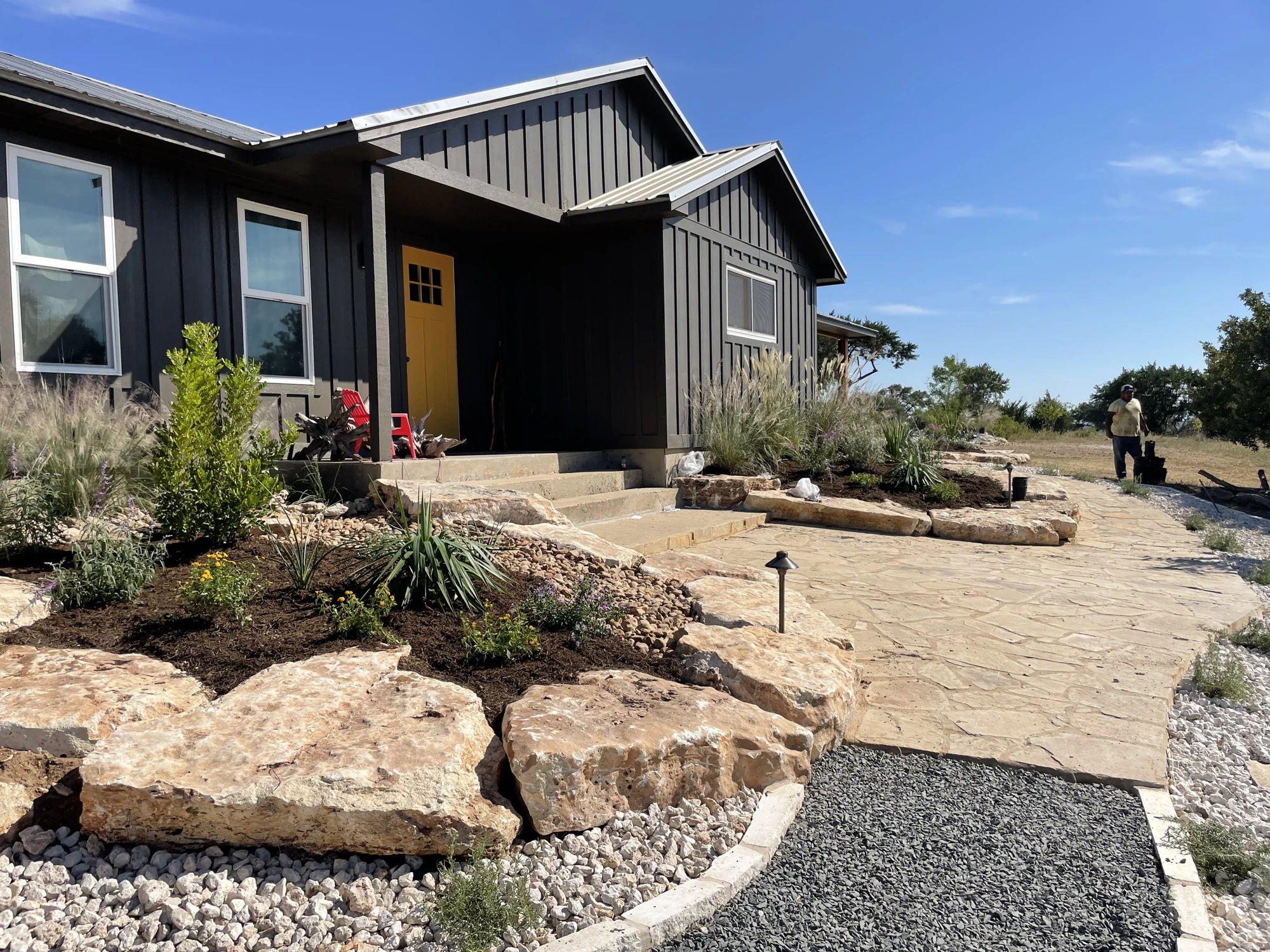 Masoned patio and stone-edged planting around a home